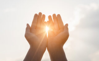 Human,hands,praying,to,god,on,mountain,sunset,background