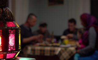 Family sitting at table by decorative light